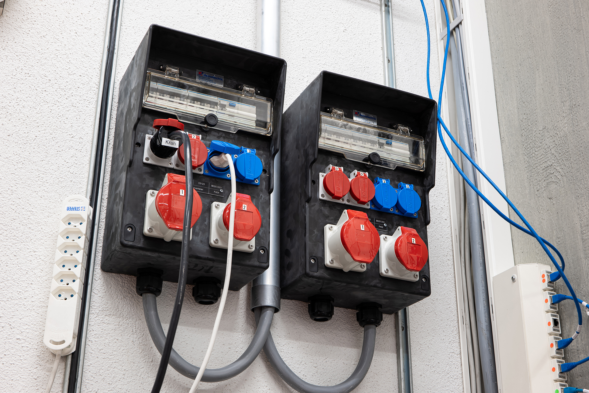 Wall mounted industrial electrical power socket and fuse box with plugs and cables